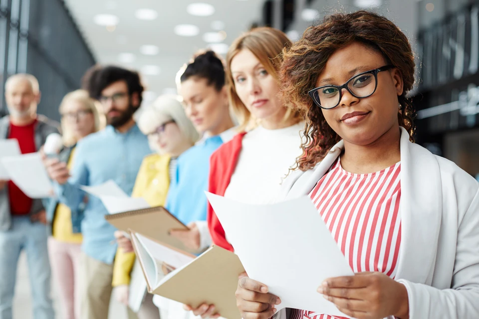 Afro-Américaine jeune femme chercheuse d'emploi parlant à professionnel masculin HR manager vérifier cv numérique sur tablette lors du processus de réunion d'entretien